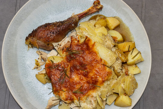 Rustic Dutch Oven Chicken: Roasted chicken drumsticks served with creamy baked potato gratin.
