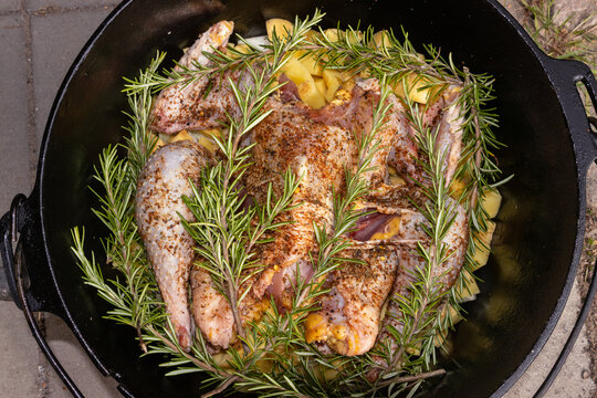 Preparing a seasoned whole chicken for outdoor Dutch oven cooking