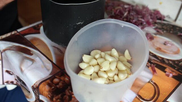 M&atilde;os preparando comida caseira em cozinha simples, cortando legumes, ervas, cebola e alho
