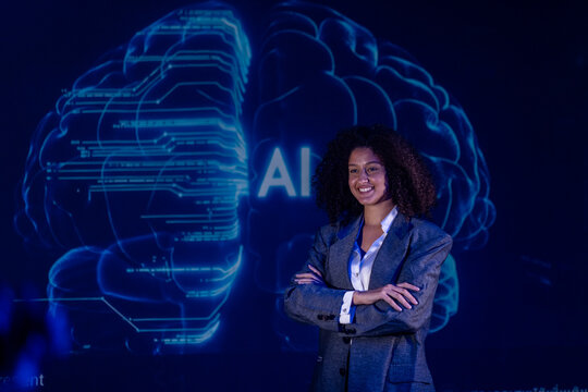 Woman standing confidently with arms crossed in front of a digital brain display during a technology presentation on AI