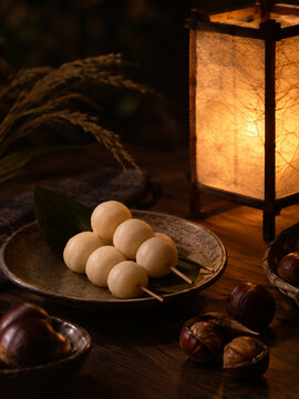 Traditional Japanese Tsukimi Dango and Chestnuts with Glowing Andon Lantern.