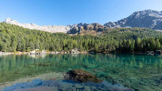 Turquoise waters of Lagh da Saoseo in the Engadin Alps surrounded by autumn nature, creating a peaceful, almost surreal scenery symbolizing mindfulness, clarity, letting go and inner calm.