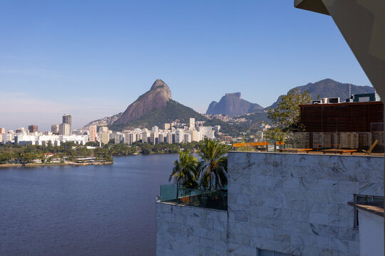 Panoramic view of Rio de Janeiro featuring Rodrigo de Freitas Lagoon and Two Brothers Hill from a luxury rooftop terrace during a sunny day