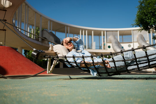 Woman Resting in a Hammock in Sunlit in the city