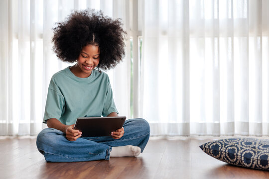 Happy girl using a tablet at home