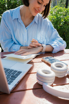 A woman checking her smartwatch while working in the garden