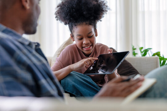 Father and daughter bonding while using a tablet together