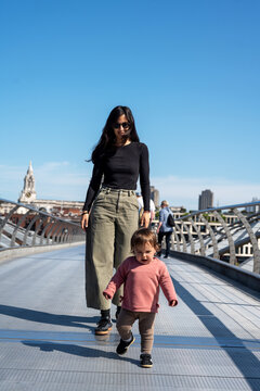 Mother Walking With Toddler On Millennium Bridge In London