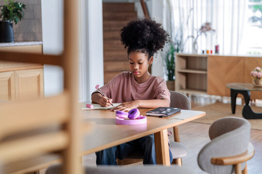 A young girl studying at a table at home