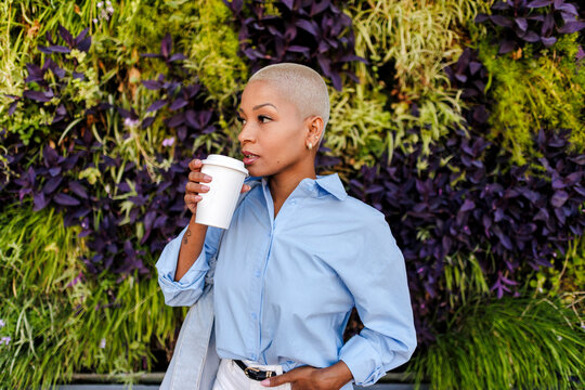 Woman drinking coffee enjoying green urban environment