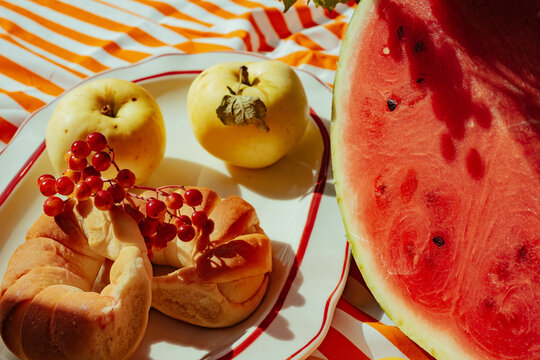 Fresh fruits and pastry on a plate set on a striped tablecloth