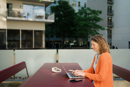 Remote Worker Using Laptop at Public Desk in Business area