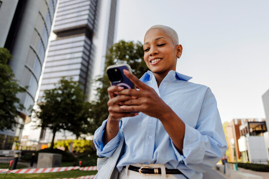 Young woman interacting with smartphone in urban setting