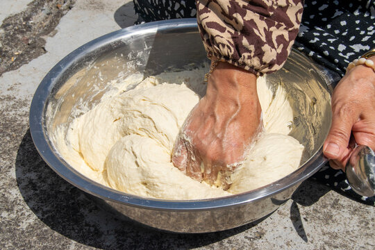 Close-up of Woman Kneading Dough by Hand in Metal Bowl