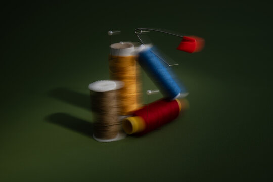 Spools of Thread Motion Blur against a dark green background