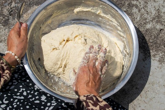 Close-up of Woman Kneading Dough by Hand in Metal Bowl