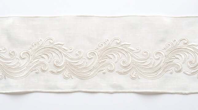 Elegant white fabric trim with intricate raised scrollwork embroidery.