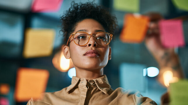 Entrepreneur arranging colorful sticky notes into a swot analysis grid on a glass wall, business strategy, innovation process, with copy space