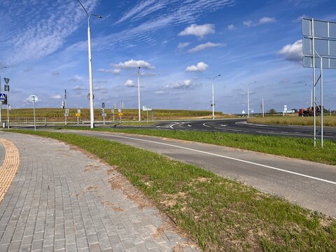 Urban road with pedestrian and bicycle paths under blue sky