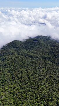 Aerial view of dense mountain forest, clouds and lagoon in Heredia, Costa Rica