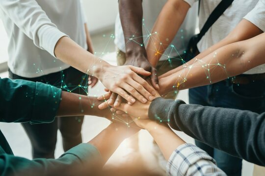 Diverse group of people putting their hands together in a circle