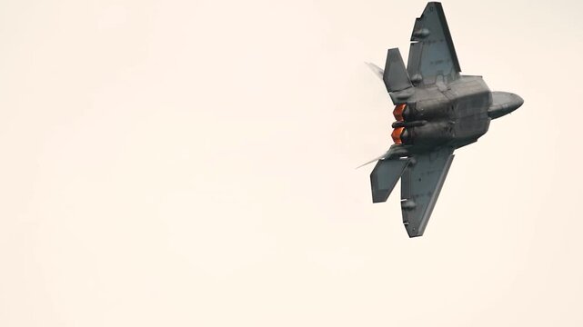 Stealth Fighter Jet Soars Vertically into Cloud-Covered Sky with Afterburners Ignited in Full Thrust.