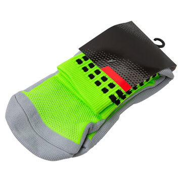 Pair of neon green and grey athletic socks in paper packaging isolated on white background