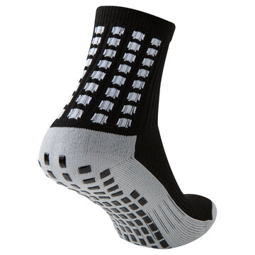 Black and grey anti slip athletic sock with rubber grips on sole isolated on white background