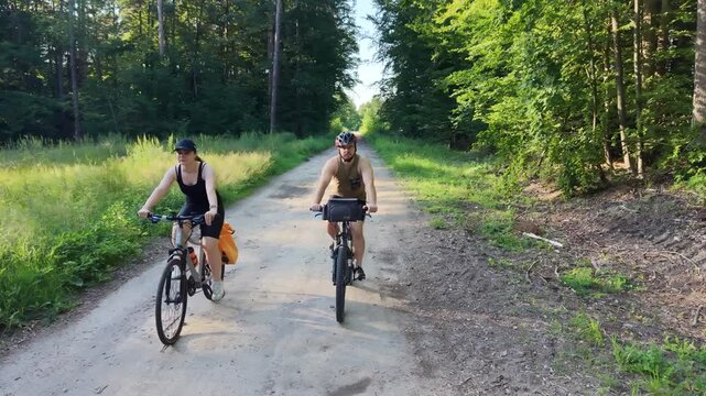 Active couple biking on rural forest trail together