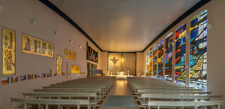 Bennwihr, France - 08 21 2026: Church of Saints Peter and Paul. Panoramic view of the nave and its stained-glass windows, a Carrara marble altar and the Stations of the Cross