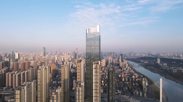 Aerial view of modern city skyline with skyscrapers and river at sunset in Wuhan, China