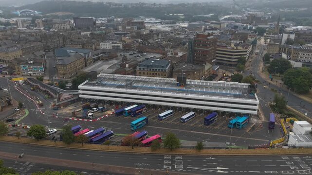 ​Aerial flyover of city center bus terminal with buses arriving and leaving, stock video. Timelapse of Huddersfield Bus Station