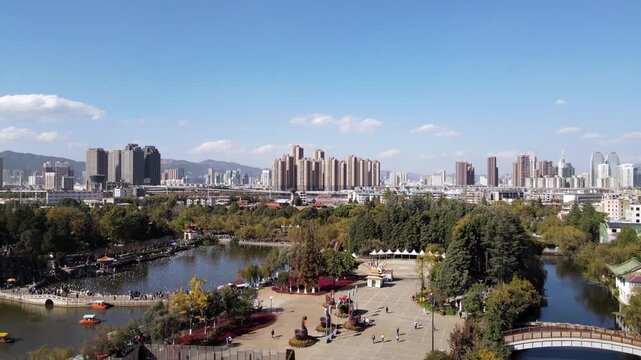 Urban Park Lake with Pedal Boats and City Skyline in Autumn