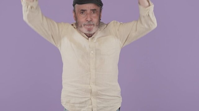 Excited mature man with a flat cap celebrating success and jumping for joy