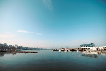 Obraz premium Contemporary landscape showcasing calm water, distant city skyline, and modern marina structures in Constanta, Romania, capturing the essence of urban design and negative space utilization