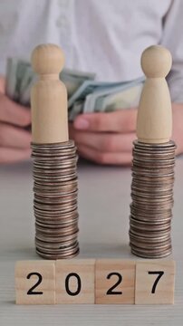 Growing stacks of coins show progress from 2021 to 2027