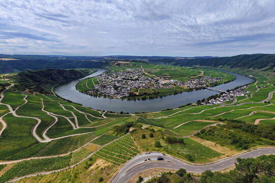 Panoramablick auf die ber&uuml;hmte Moselschleife bei Piesport. Die malerische Flussschlinge schmiegt sich an steile, gr&uuml;ne Weinberge und den idyllischen Weinort an der Mosel.