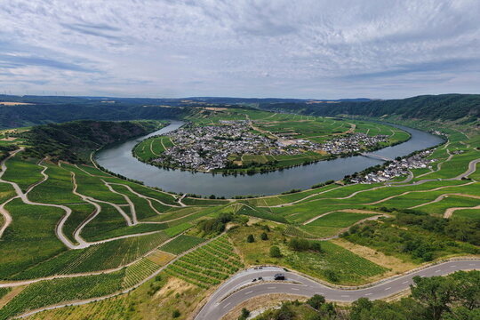 Panoramablick auf die ber&uuml;hmte Moselschleife bei Piesport. Die malerische Flussschlinge schmiegt sich an steile, gr&uuml;ne Weinberge und den idyllischen Weinort an der Mosel.