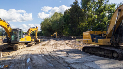 Yellow excavators are clearing the site for future construction. © yaviki