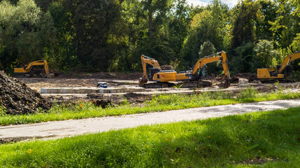 Yellow excavators clearing a construction site. Heavy machinery © yaviki