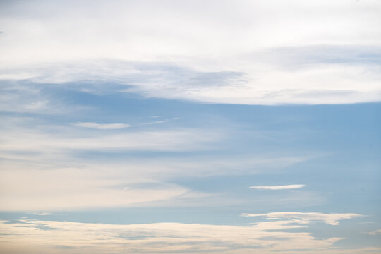 Peaceful sky background with soft white cloud layers in calm blue atmosphere filled with daylight creating serene natural mood