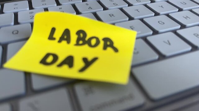 Labor day sticky note on laptop keyboard with copy space