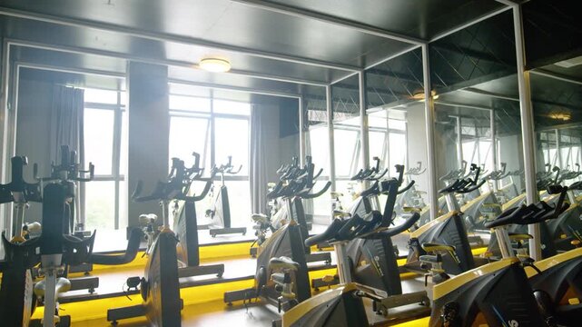 Rows of Stationary Bikes in a Modern Indoor Cycling Studio with Mirrors