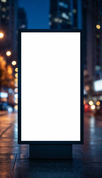Blank vertical city billboard mockup standing on a wet urban street at night