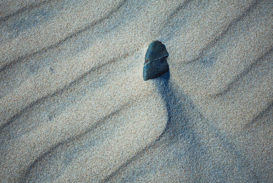 Close-up abstract of perfect wind ripple patterns in white sand dunes forming gentle waves