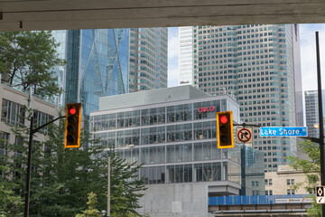 Obraz premium looking north from Lake Shore Blvd beneath the elevated Gardiner Expressway to CIBC Square podium office spaces and signs on Yonge St, Toronto