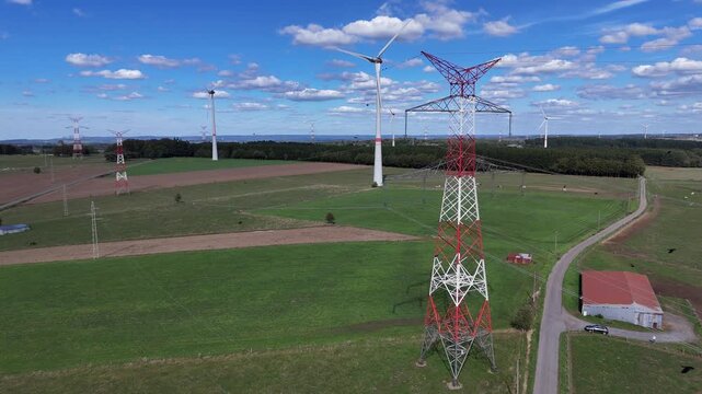 vue a&eacute;rienne panoramique des &eacute;oliennes et des pyl&ocirc;nes &agrave; haute tension &eacute;lectrique qui produisent et  transportent l'&eacute;nergie dans la r&eacute;gion de Bastogne, en Belgique, pr&egrave;s du village de Sibret. 