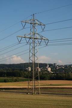 Hochspannungsmast auf einem Feld am Stadtrand von Z&uuml;rich, Strommast einer &Uuml;berlandleitung in l&auml;ndlicher Umgebung