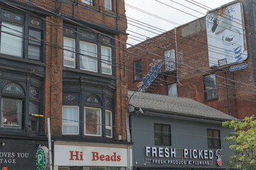 Fototapeta premium historic exterior building facade and sign of Hi Beads located at 543 Queen St W, and Fresh Picked, a produce and flower seller, located at 545 Queen St W (near Augusta Av), Toronto