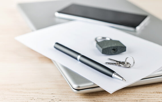 Padlock and keys on paper over a laptop for cybersecurity and privacy